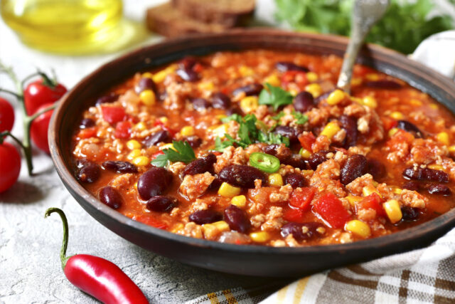Brzi ručkovi u ekspres loncu - recept za veganski cili posluzen u tanjiru i dekorisan ljutom papričicom.